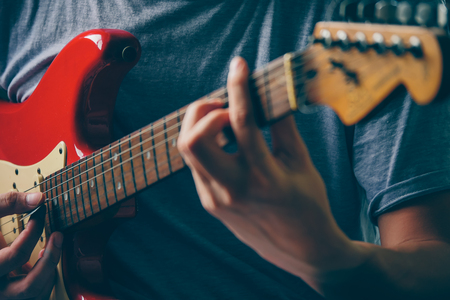 Close up of male hands playing electric guitar. Selective focusの写真素材