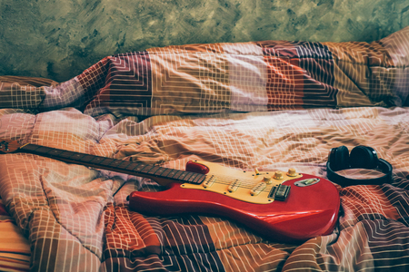 Electric guitar and headphones in bedroom, Films grain filter.の写真素材