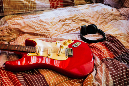 Electric guitar and headphones in bedroom, Films grain filter.の写真素材