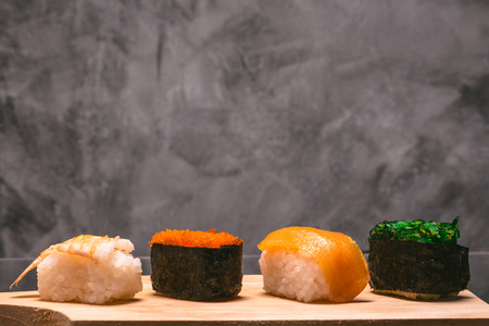 Sushi set on wooden plate on gray grunge background, Japanese food.の写真素材