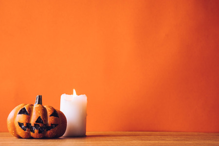 Halloween pumpkin with candlelight on an orange color background. Free space for textの写真素材