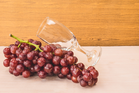 Red grapes with wine glass on the wooden table. Free space for textの写真素材
