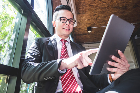 Young asian businessman using tablet computer in the office.の写真素材