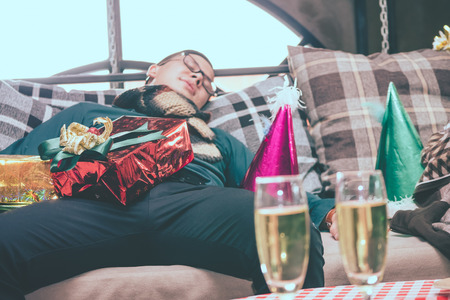 Sleeping man on a sofa after Christmas party.の写真素材
