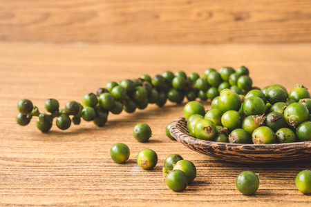 Green peppercorns on wooden background.の写真素材