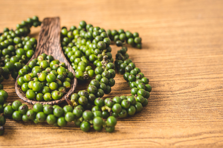 Green peppercorns on wooden background.の写真素材
