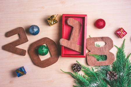 Wooden numbers 2018 with Christmas decoration on wooden background.の写真素材
