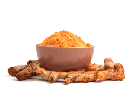 Turmeric roots with turmeric powder on white background.の写真素材