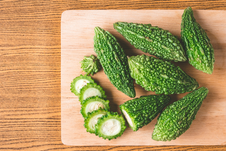Bitter melon or bitter gourd on wooden tray. Free space for taxtの写真素材