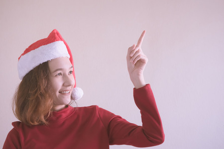 Portrait of Happy Asian woman dressed in red Christmas hat and red sweater.の写真素材