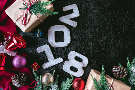 Top view of Wooden numbers 2018 with Christmas decorations on black background. Free space for text