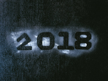 The numbers 2018 written on the white snow on a black background. Happy New Year concept