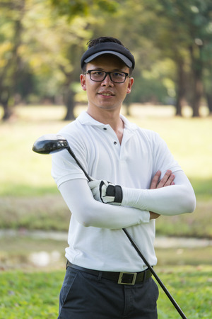 Portrait of asian young male golfer with golf club on the golf course.の写真素材