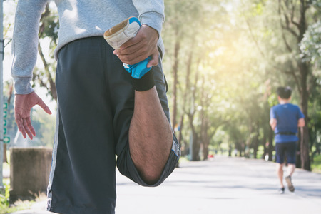 A man is stretching before running in a park at the morningの写真素材