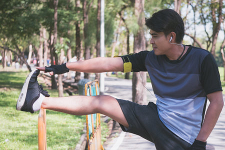 A man is stretching before running in a park at the morning
