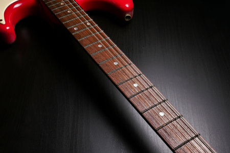 Close up of Electric guitar body and neck detail on black background.
