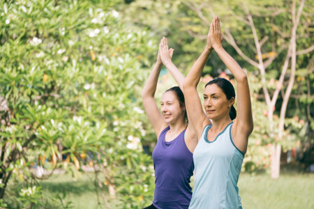 Group of women doing yoga exercises in the park. Concept of healthy lifestyle.の写真素材