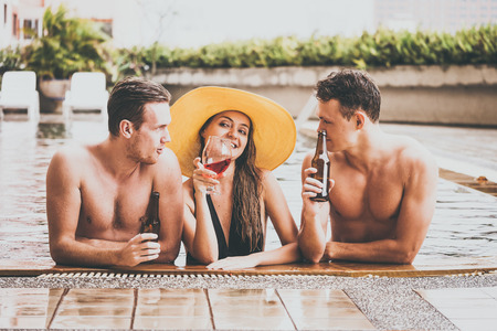 Group of friends enjoying vacation in summer time. Young people having fun in swimming poolの写真素材