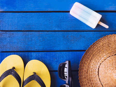 Top view of Summer accessories on blue wooden floor. Free space for textの写真素材