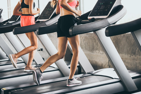 Young people running on the treadmill at the gymの写真素材