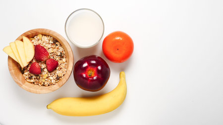 Top view of Oatmeal flakes, milk, and fresh fruits on white background. copy space