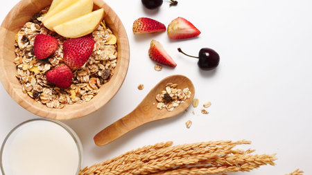 Top view of Oatmeal flakes, milk, and fresh fruits on white background. copy space