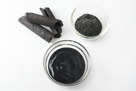 Facial mask and scrub by activated charcoal powder on white backgroundの写真素材