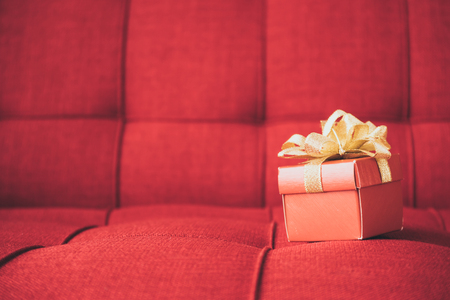 A gift box on red sofa. Free space for textの写真素材