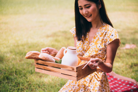 Close up of woman enjoying picnic in a park.の写真素材