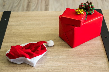Top view of red gift boxes and hat on wooden tableの写真素材