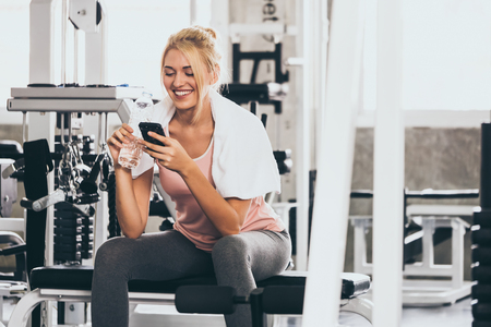 Attractive young woman taking a break after exercise at the gymの写真素材