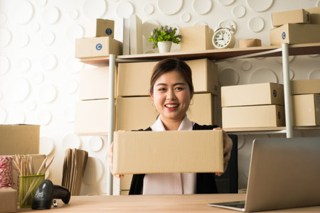 Happy woman success in her owner small business online with package box.