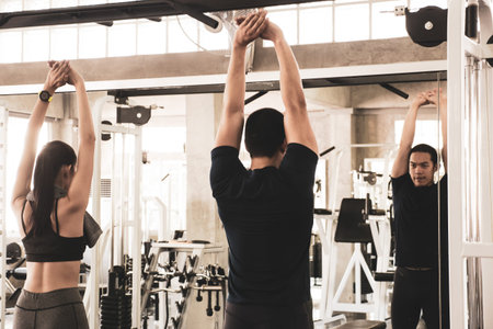 Young couple stretching and warming up before workout at the gym