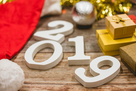 Top view of Christmas hat, 2019 number and gift boxes on wooden background.の写真素材