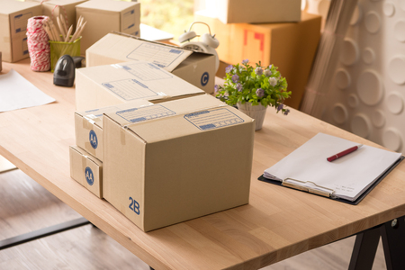 Many boxes of goods on wooden table at the office.の写真素材