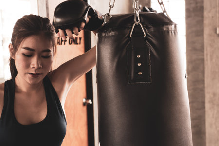 Young athletic girl fighter trains in the gym.