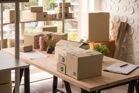 Many boxes of goods on wooden table at the office.の写真素材