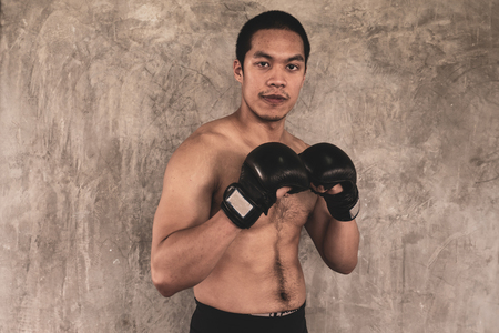 Portrait of  sportsman in boxing gloves on grunge backgroundの写真素材