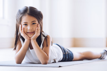 Portrait of a cute little Asian girl lying down on the floor