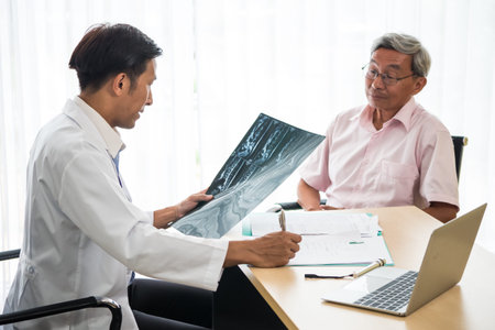 Expert doctor examining and explaining x-ray film to patient