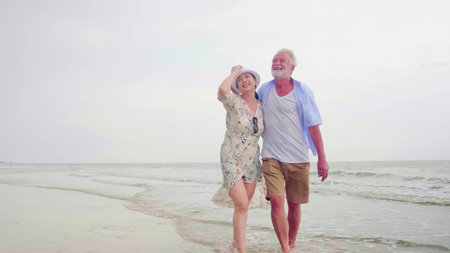 Happy couples walking together on the beach.の写真素材