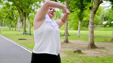 Beautiful chubby woman streching in the park.の写真素材