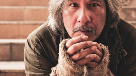 Homeless man sitting on stairs.の写真素材