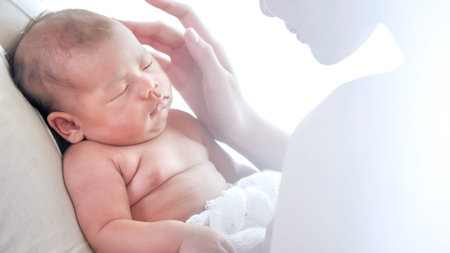 Happy mother taking care of sleeping baby in the room.