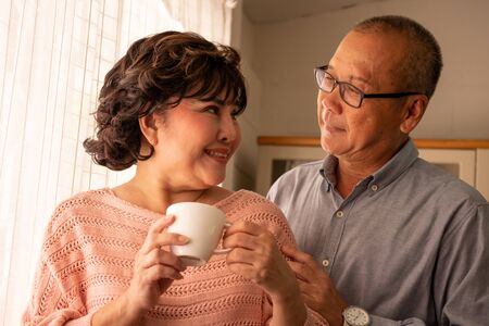 Happy asian couples standing together in the house.の写真素材