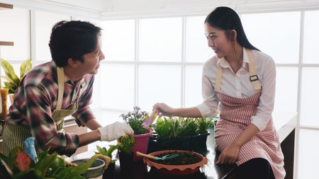 Happy gardener couple taking care of seedling together in the room.