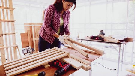 Female carpenter fitting pieces of boards together at site.の写真素材