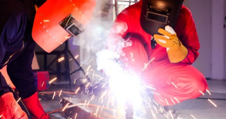 Male welders working together at site.