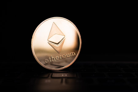 A golden coin with ethereum symbol on computer keyboard.
