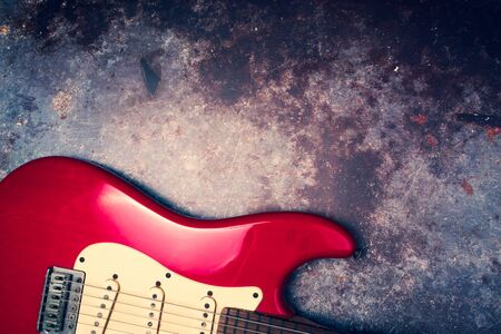 A red electric guitar on a grunge background.の写真素材